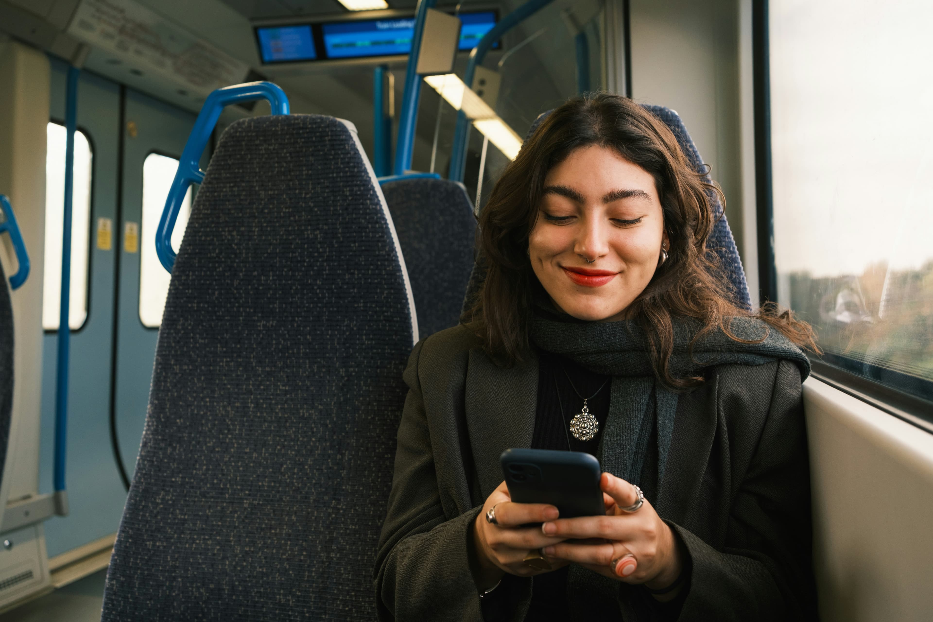 Persona usando su teléfono con datos móviles mientras viaja en tren
